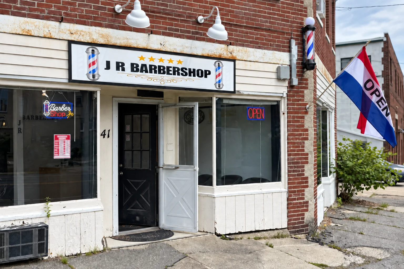 JR Barbershop storefront with an open door and a flag