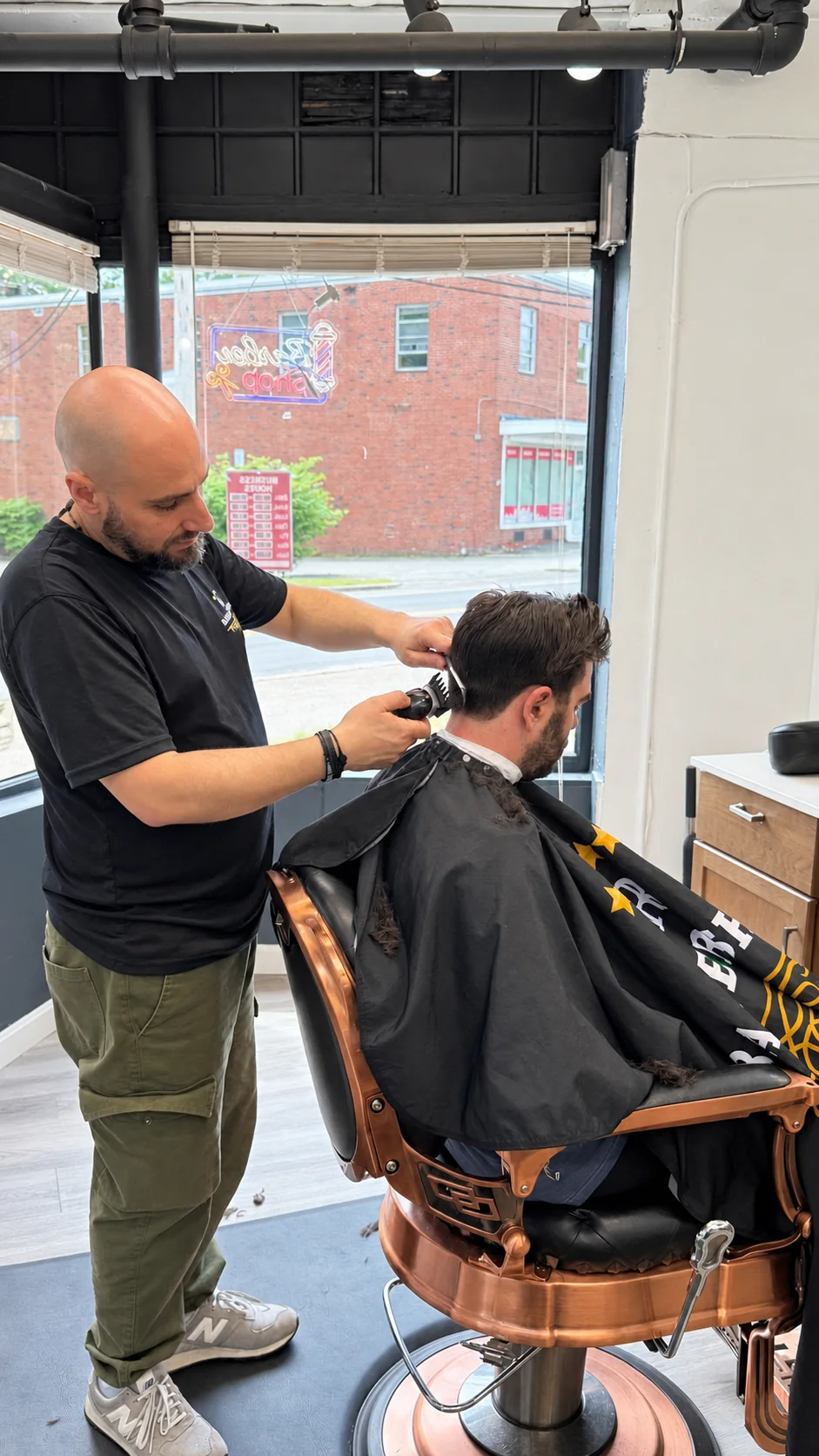 Barber using clippers at the back of a customer's haircut